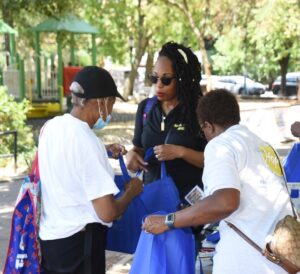 Lisa Farray Atkins and Antoinette Neil handing out promotional item